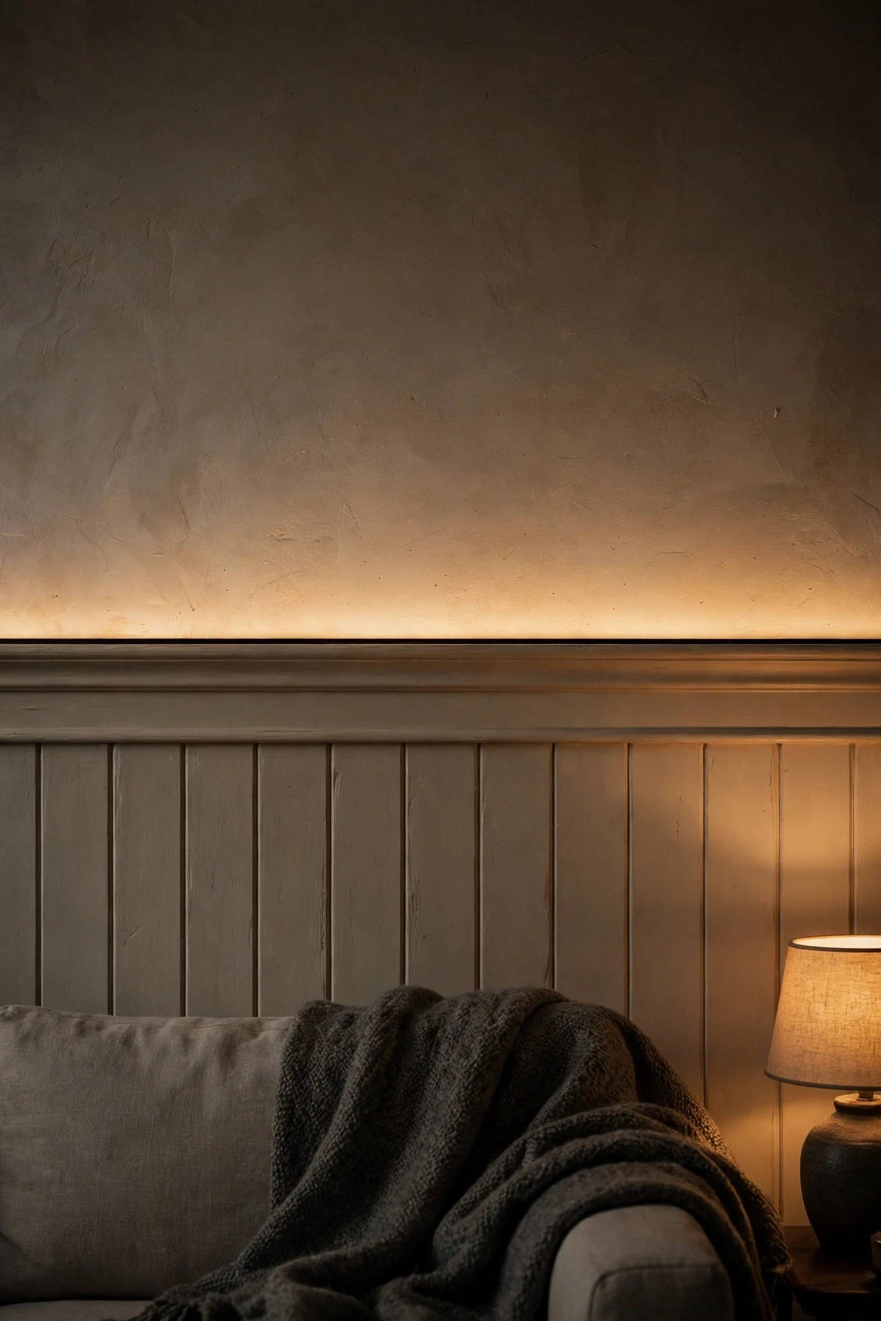 Warm LED cove light hidden above a wainscoting cap rail in a living room